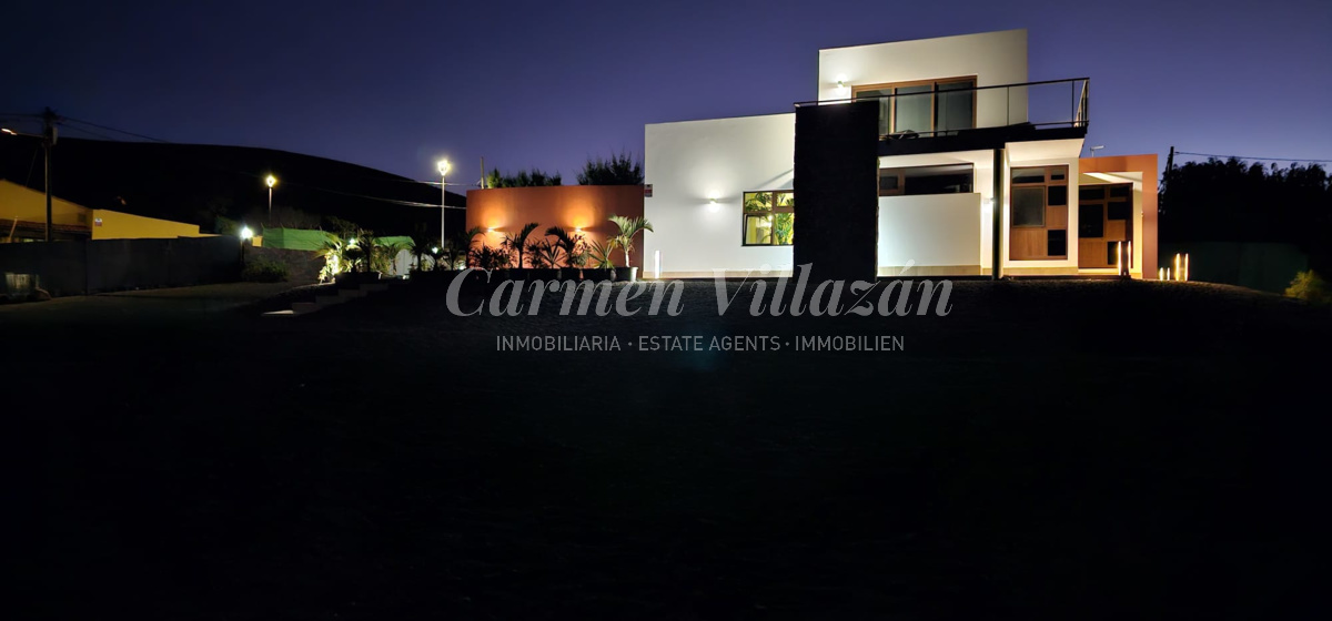 Fachada de noche de la villa en Los Estancos.
