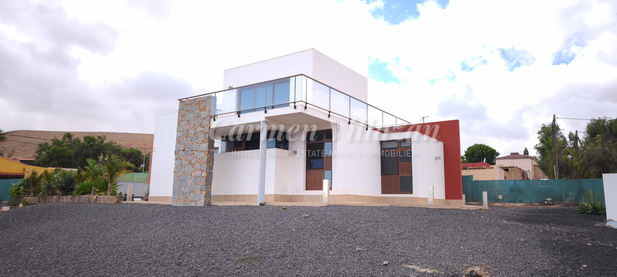 Fachada lateral de día de la villa en venta.