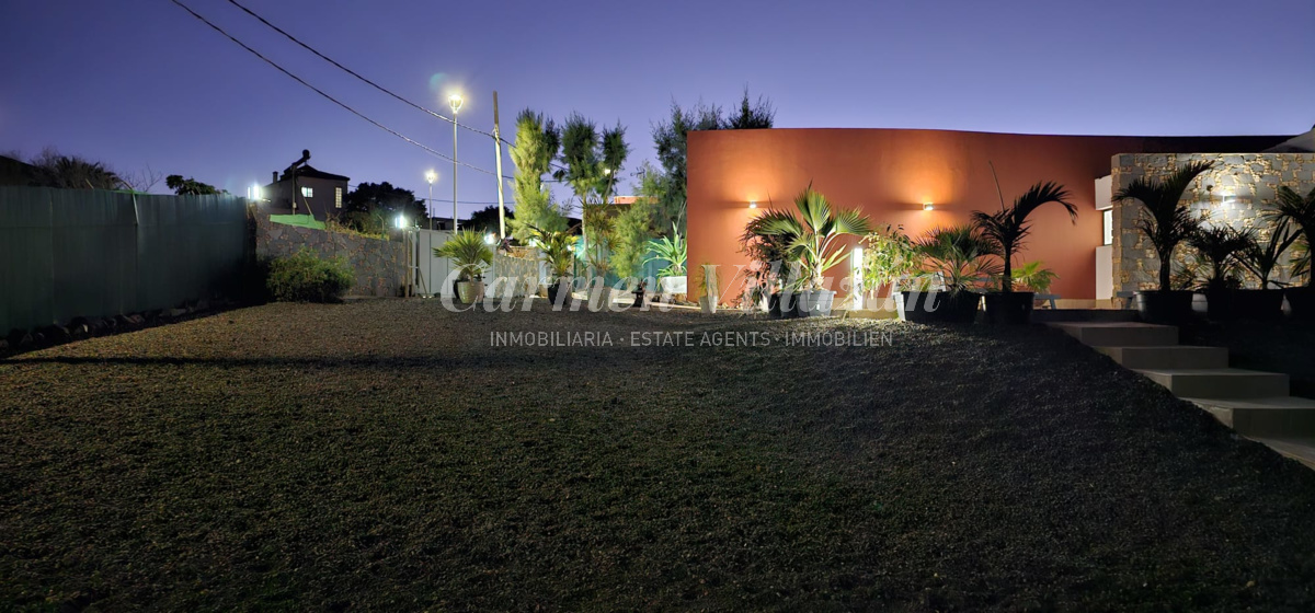 Entrada a la villa iluminada por la noche