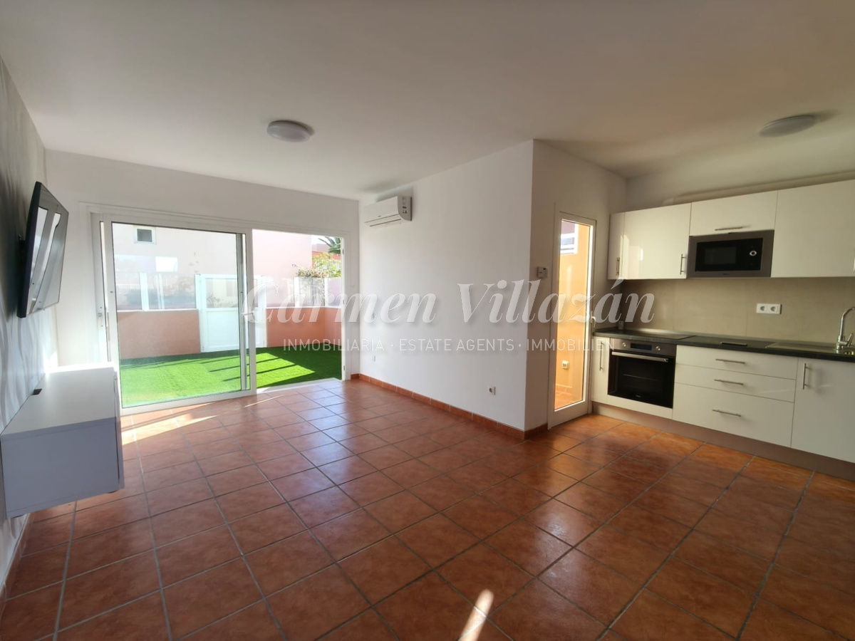 Salón con acceso a la terraza trasera en el apartamento en venta en Las Fuentes, Corralejo.